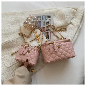 Close-up of pink quilted vanity bags with gold flower accents and chain straps