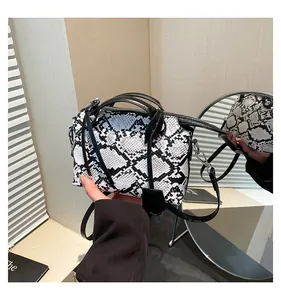Detail of black and white snakeskin pattern texture on chic handheld bag with dual handles