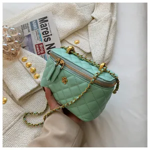 Detail of mint green quilted bag featuring gold floral buckle and chain strap