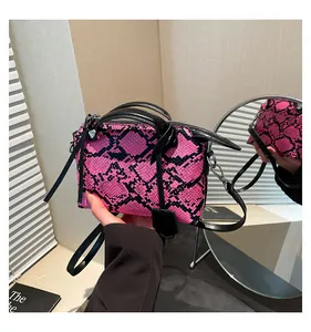 Detailed macro of pink snake print handbag with silver hardware and black top handles