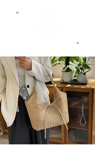 Détail d'un sac cabas en paille minimaliste avec nœud décoratif et bandoulière en cuir