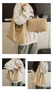 Detail view of khaki canvas tote bag with matching zipper pouch and small blue side label
