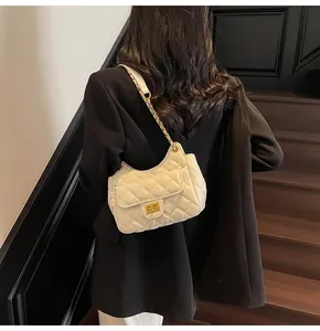 Dettaglio della borsa in pelle trapuntata bianca con catena dorata e chiusura a scatto
