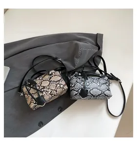 Detailed view of snake skin pattern texture on stylish crossbody handbags in two colors