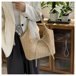 Vue détaillée du sac cabas en paille tissée avec grand nœud et texture à chevrons