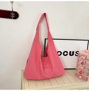 Macro shot of minimalist bright pink canvas hobo tote bag with a small blue label detail