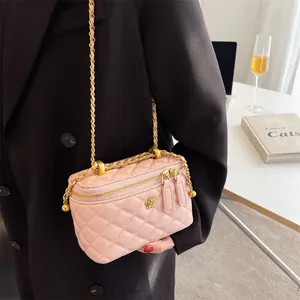 Pink quilted crossbody chain bag with floral gold hardware on an aesthetic table setting