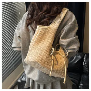 Détail d'un grand sac fourre-tout tissé avec des glands à franges et des bordures en cuir