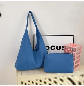Detailed set of blue canvas tote bag and matching zipper pouch on a shelf