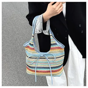 Détail du sac cabas tissé à rayures multicolores avec un nœud et des poignées en cuir