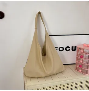 Close-up of khaki canvas tote bag showing thickened fabric texture and wide shoulder strap