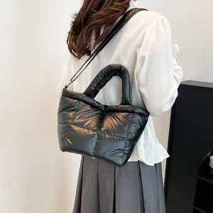 Chic black quilted down tote bag with plush handles and adjustable strap for winter casual style