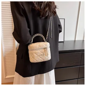 Dettaglio della mini borsa a scatola trapuntata bianca con manico di perle e catena d'argento