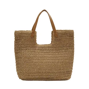 Handwoven straw tote bag with brown leather handles and spacious U-shaped opening design