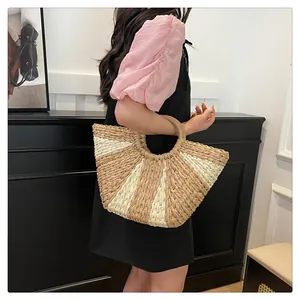 Détail du sac cabas en paille tissé avec rayures kaki et poignée ronde design
