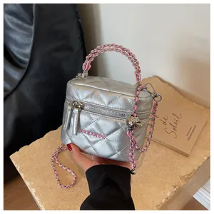 Dettaglio della mini borsa a scatola argento trapuntata con catena rosa e stampa a cuore