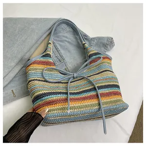 Détail du sac cabas tissé à rayures colorées avec nœud en cuir bleu clair et bandoulière