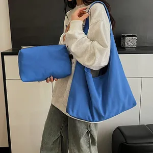 Minimalist Klein blue canvas tote bag set with a matching pouch shown on a model