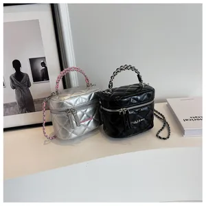 Dettaglio della borsa a scatola trapuntata con doppia zip e manico a catena in metallo