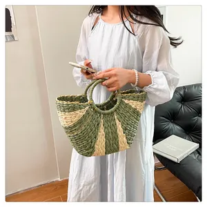 Gros plan d'un sac cabas tissé avec rayures vertes et poignées circulaires rigides