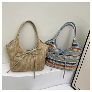 Détail de sacs fourre-tout en paille tissée avec rayures colorées et nœuds décoratifs