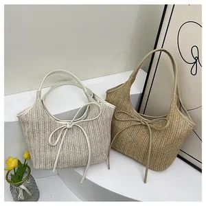 Détail de sacs cabas en paille avec des nœuds décoratifs et un design de grande capacité