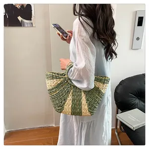 Détail du sac cabas en paille tissée avec silhouette en éventail en vert et beige