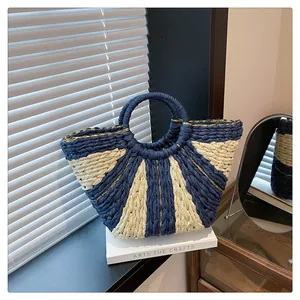 Détail d'un sac cabas tissé en éventail avec rayures bleu marine et fils dorés