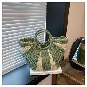 Détail du sac cabas tissé vert et crème avec fils métalliques et poignées rondes