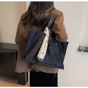 Λεπτομέρεια vintage μαύρης τσάντας tote με καπιτονέ σχέδιο και διακοσμητικό λουράκι