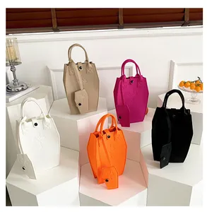 Detail of coffin-shaped tote bags in five colors with cross embroidery and matching pouches