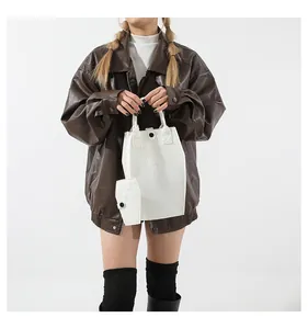 Fashion model holding a white 2-piece handbag set with embossed gothic cross details.