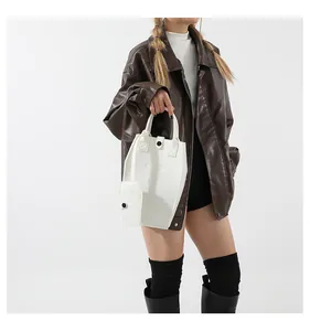 Minimalist white faux leather sub-mother handbag set shown on a model in a studio.