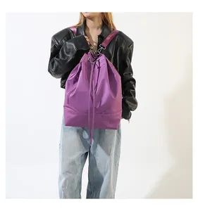 Detail eines lila Nylon-Rucksackbeutels mit Kordelzugverschluss und seitlicher Reißverschlusstasche