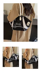 Detail of nylon tote bag featuring white embroidery and mesh side pocket accents