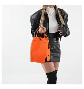 Vibrant orange coffin-shaped tote bag with embossed cross and matching small pouch