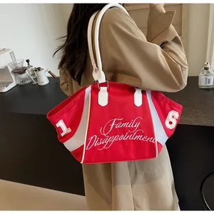 Detail of red canvas tote bag featuring white lettering and sporty mesh patchwork detail