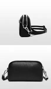 Détail du sac bandoulière en cuir grainé noir avec deux fermetures éclair argentées