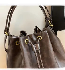 Close-up of vintage brown bucket bag featuring drawstring closure and gold metal hardware