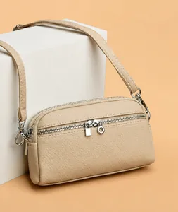 Vue détaillée du sac beige à trois fermetures éclair avec texture en cuir grainé litchi