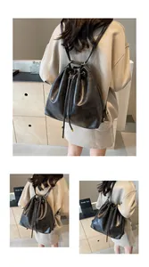 Detail view of black vintage leather drawstring backpack with metallic rings and thin straps