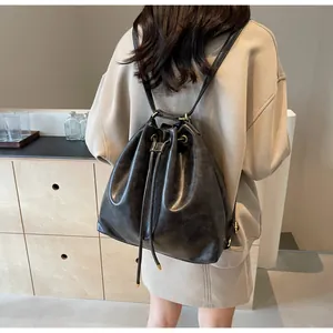 Detail of black leather drawstring bucket backpack with premium gold metal eyelets