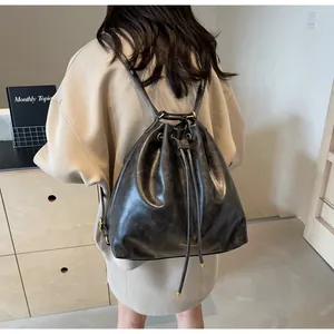 Detail view of large charcoal bucket bag with drawstring closure and golden hardware