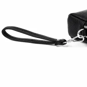 Gros plan d'un sac en cuir litchi noir avec fermoir mousqueton en argent brillant