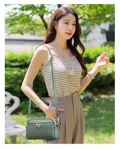 Détail du sac bandoulière vert olive multicouche avec cuir grainé et fermetures argentées