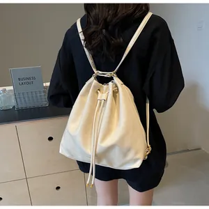 Detail of a minimalist cream bucket backpack with drawstring and fine leather texture