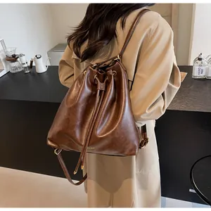 Close-up of drawstring closure and vintage brown leather texture on a bucket backpack