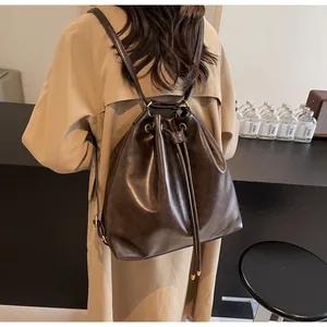 Detail of dark brown leather bucket backpack with gold eyelets and drawstring closure