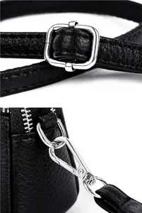 Détail de la bandoulière en cuir réglable avec boucle en métal argenté sur sac noir