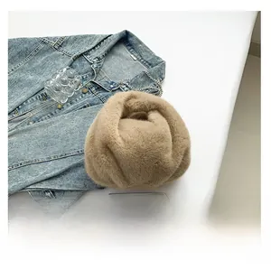 Detail view of khaki plush bucket bag next to casual denim jacket and smartphone